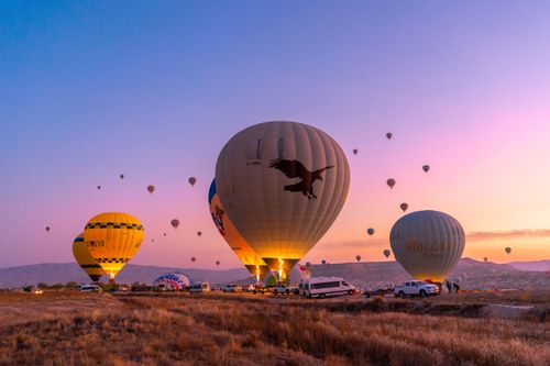 Free Vibrant hot air balloons fill the sky at sunrise in Cappadocia, Turkey. Stock Photo