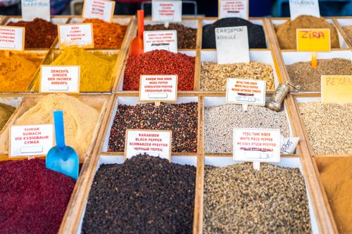 Free Close-up of a vibrant spice display in a market with labels in multiple languages. Stock Photo