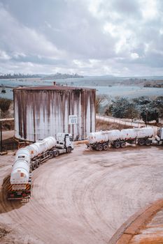 Aerial view of industrial trucks near a large silo in Serra dos Aimorés, Brazil.