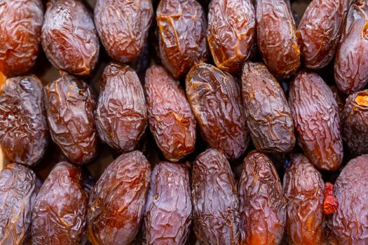 Detailed shot of fresh ripe dates in rows, ideal for food and health topics.