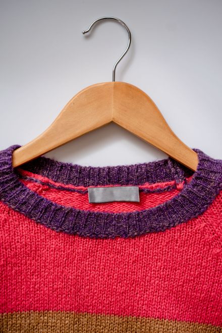 Knit sweater on a wooden hanger by Atlantic Ambience on Pexels