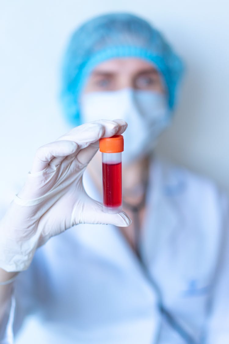 Doctor In Scrubs Holding A Vial