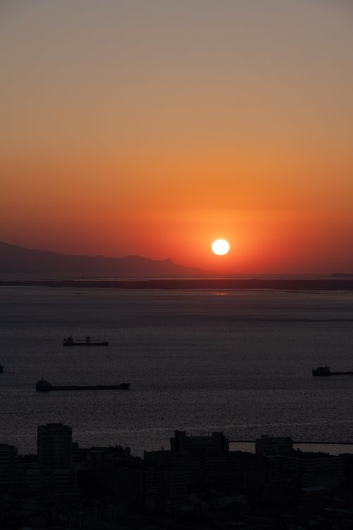Free Breathtaking sunset over the Turkish coastline with silhouetted cargo ships. Stock Photo