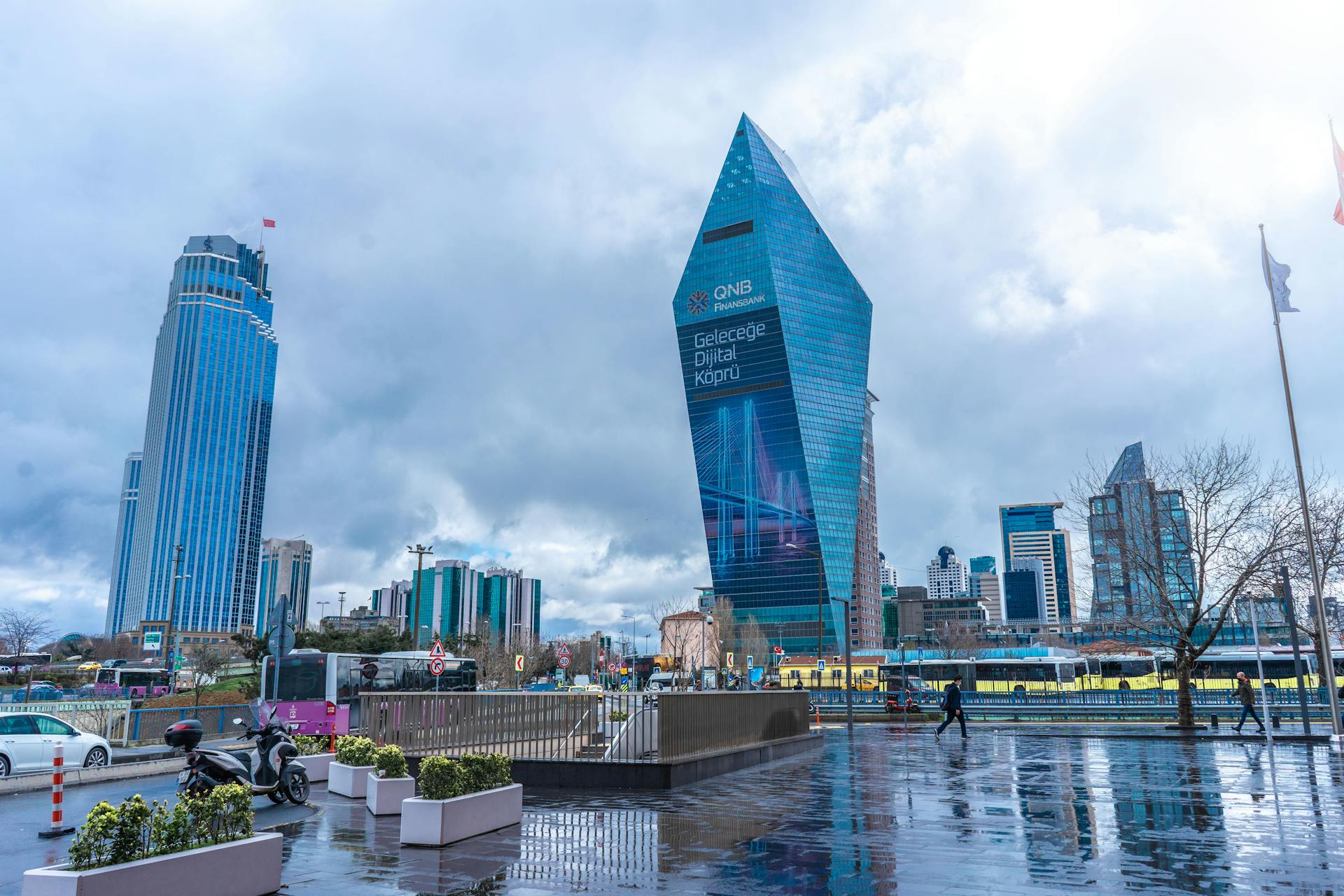 Modern Istanbul skyline featuring prominent skyscrapers and reflections on wet streets after rain.