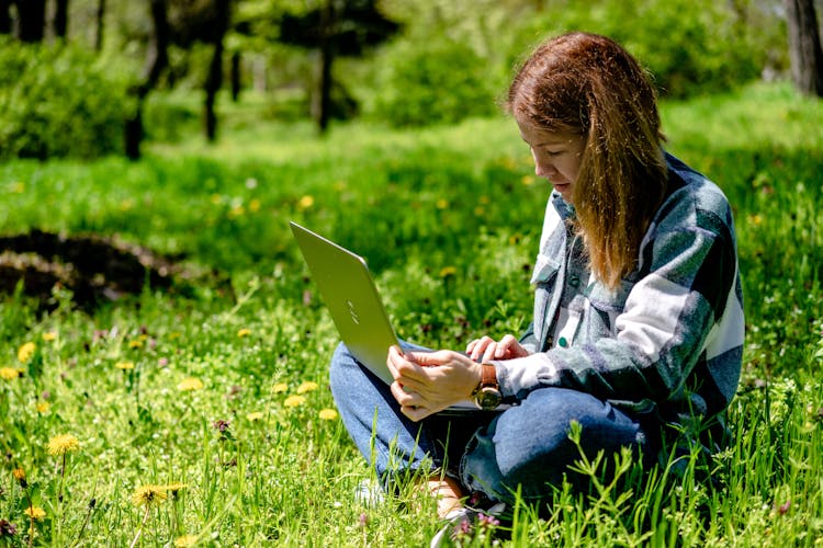 Brunette Woman Working On Laptop In Park