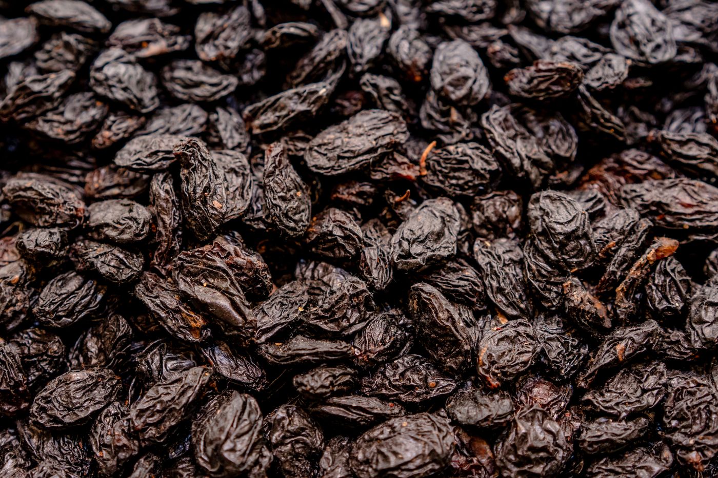 Close-up of a pile of dark, wrinkled dried prunes