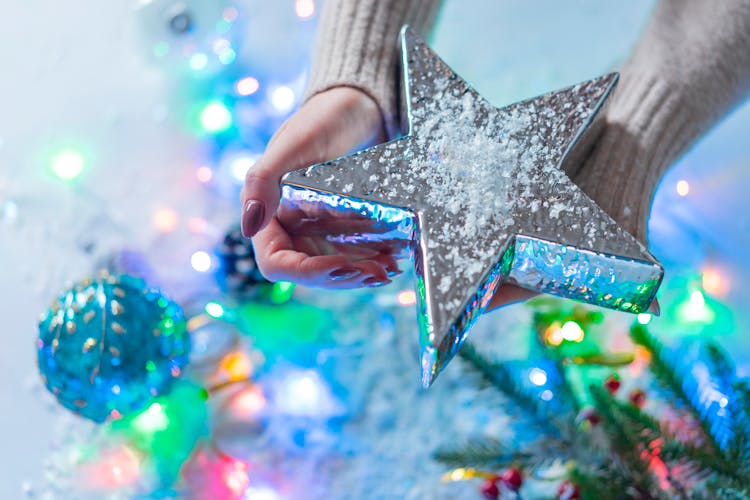 Person Holding Silver Star Ornament