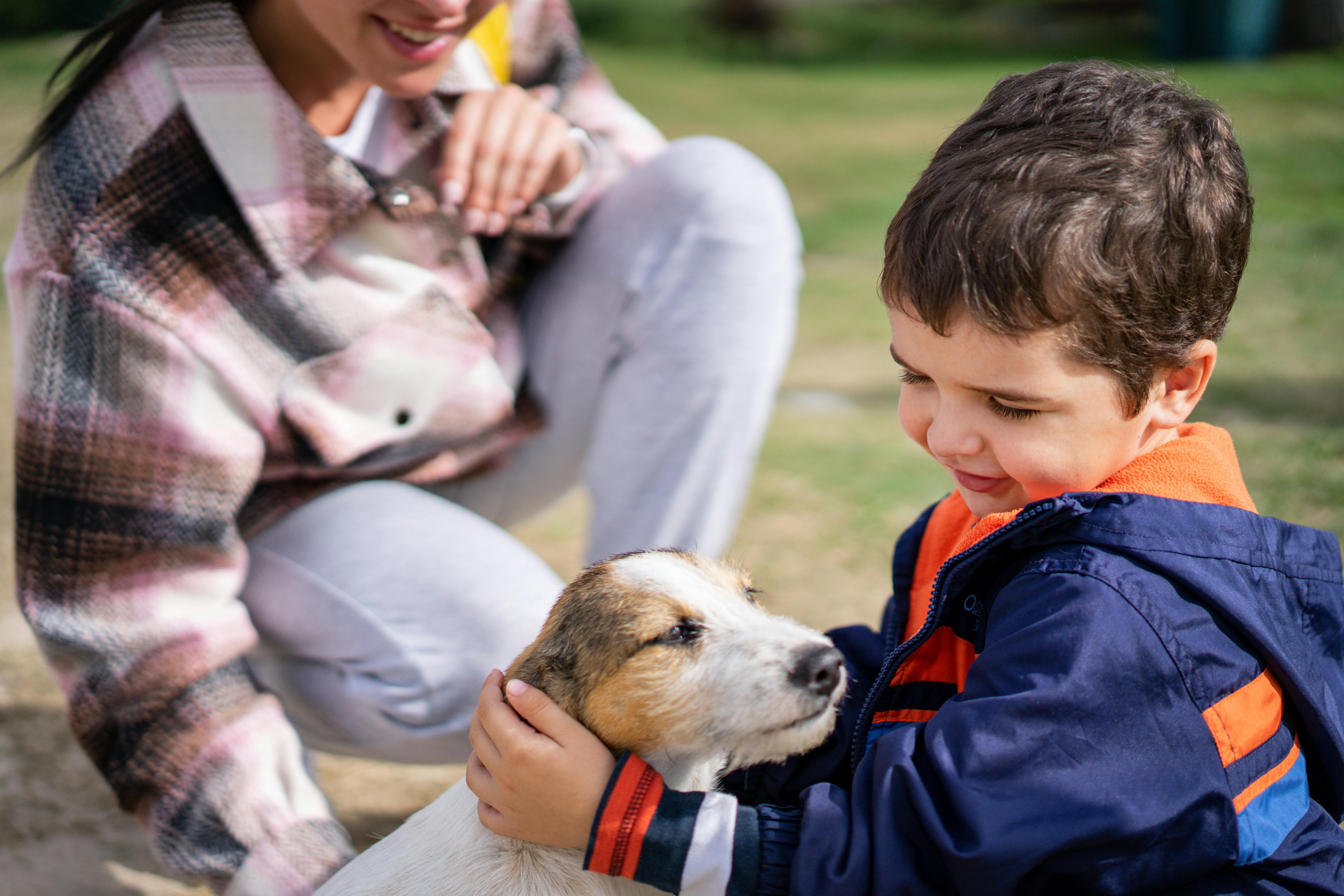 Photo of a Kid Reading a Book with His Dog · Free Stock Photo