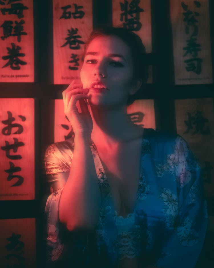 Pink Toned Portrait Of A Woman And Japanese Script On The Wall