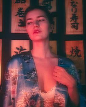 Moody portrait of a woman in a colorful kimono with Japanese script background, creating an artistic ambiance.