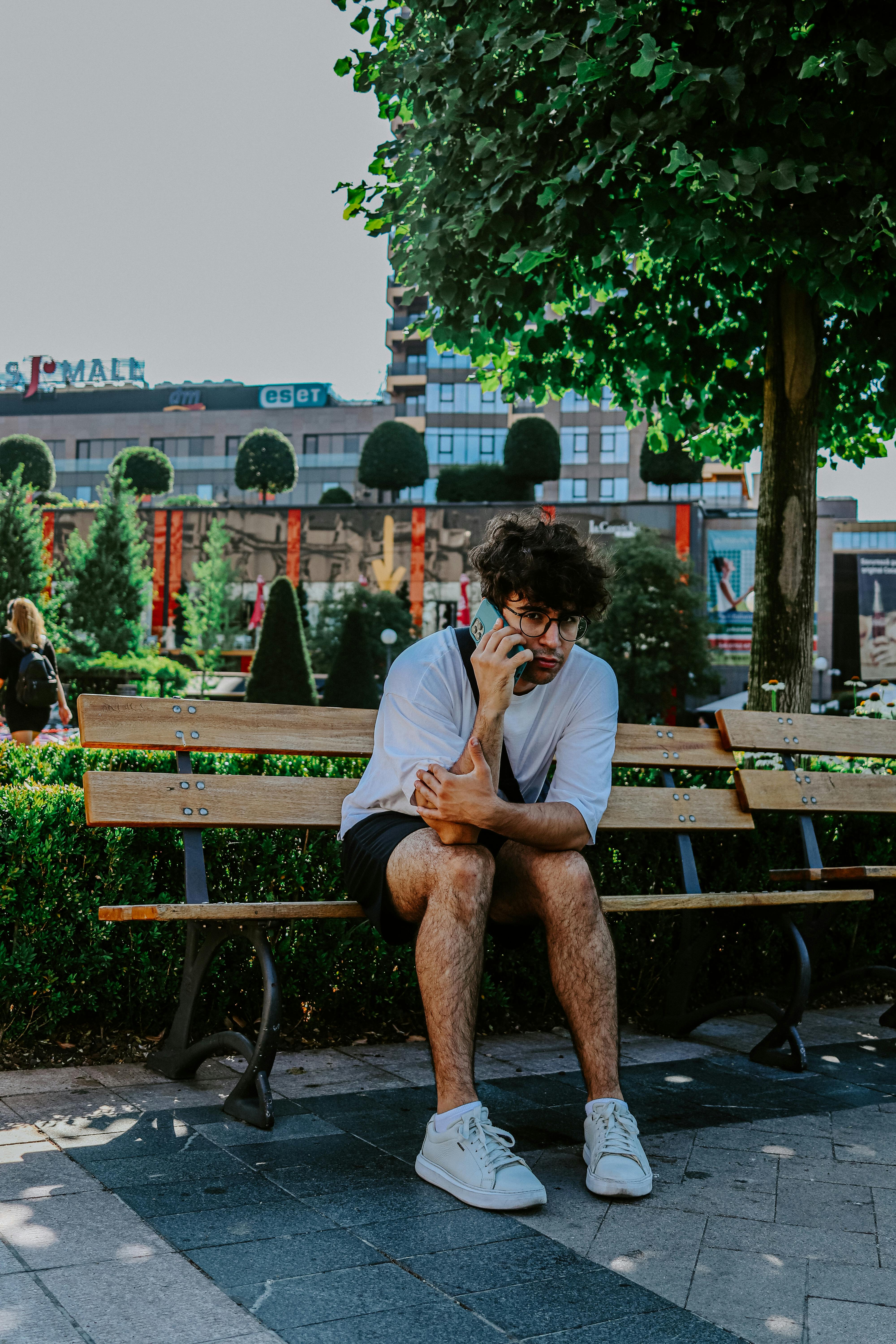 Premium Photo | Brunette girl at black dress sitting on bench and posing at  street of city