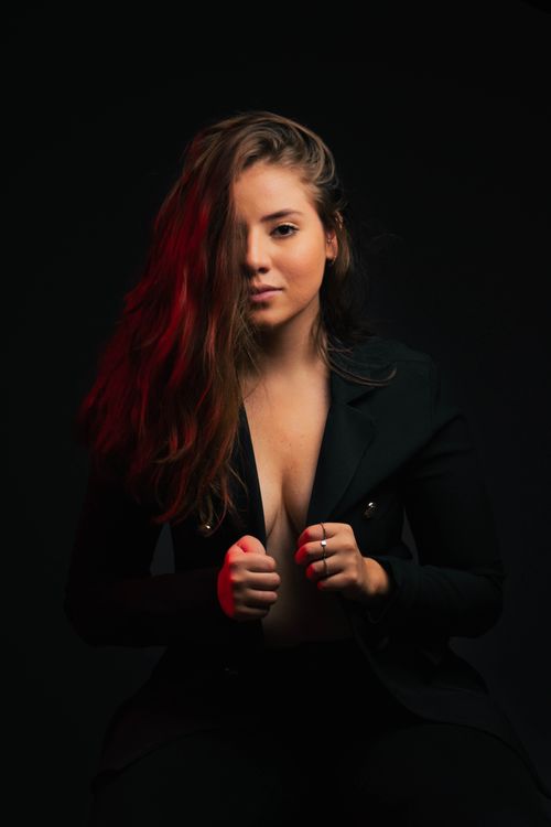 Free Intimate portrait of a woman in a black blazer with moody lighting, exuding allure and confidence. Stock Photo