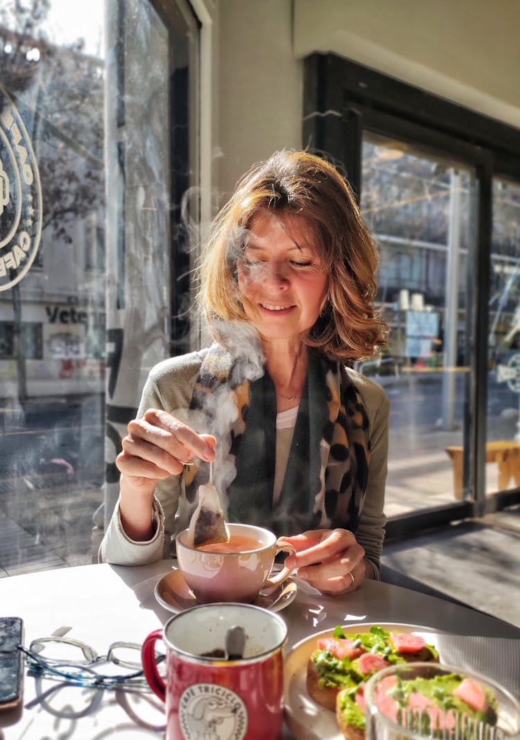 A Woman Holding A Tea Bag