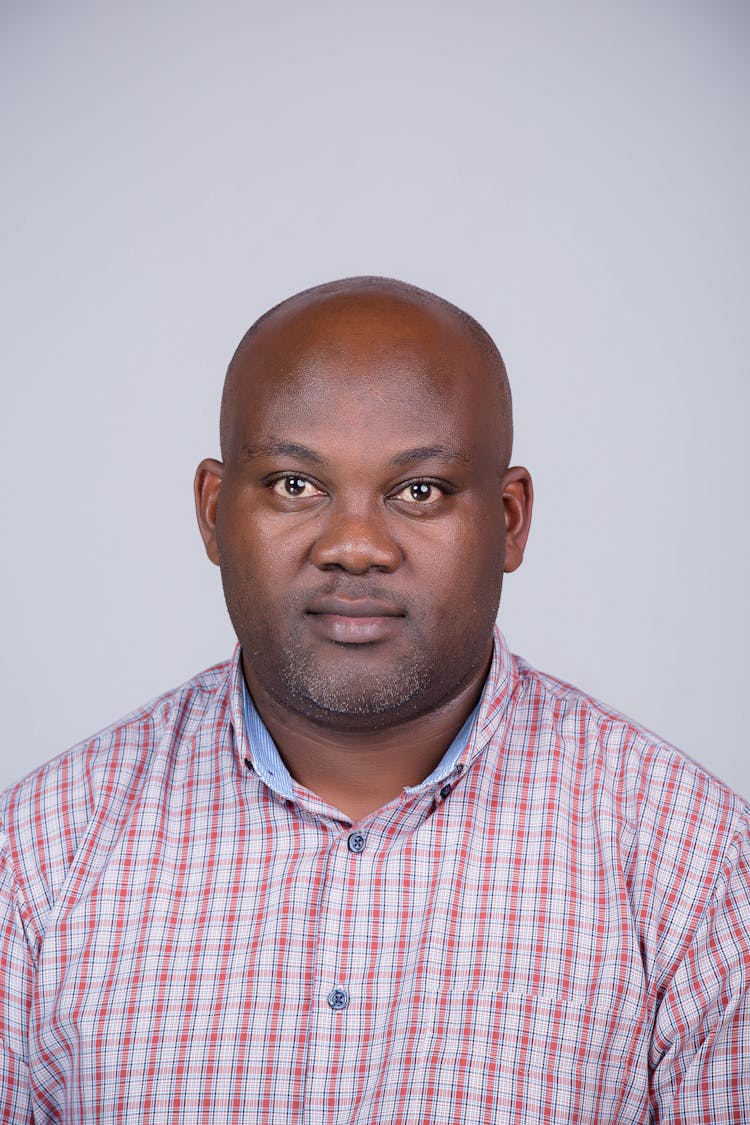 A Man In Checkered Button Up Shirt Seriously Looking At The Camera