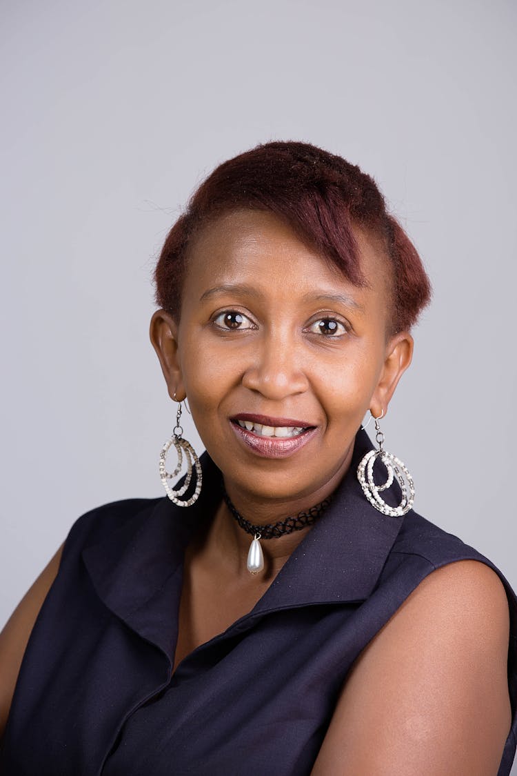 Woman In Sleeveless Top Wearing Earrings While Smiling At The Camera