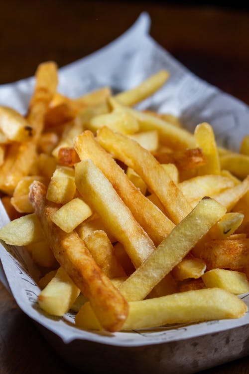 Close-up Photo of French Fries on White Paper
