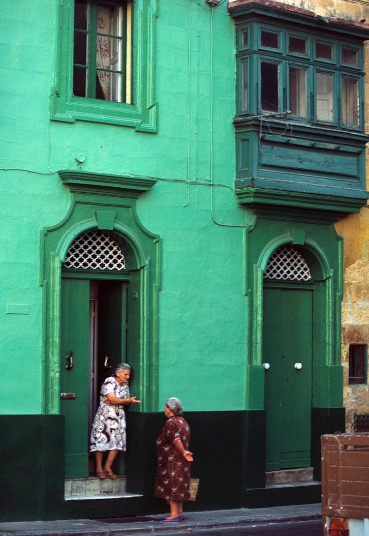 Elderly Women Talking Near Door 