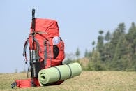 Selective Focus Photo of Red Hiking Backpack on Green Grass