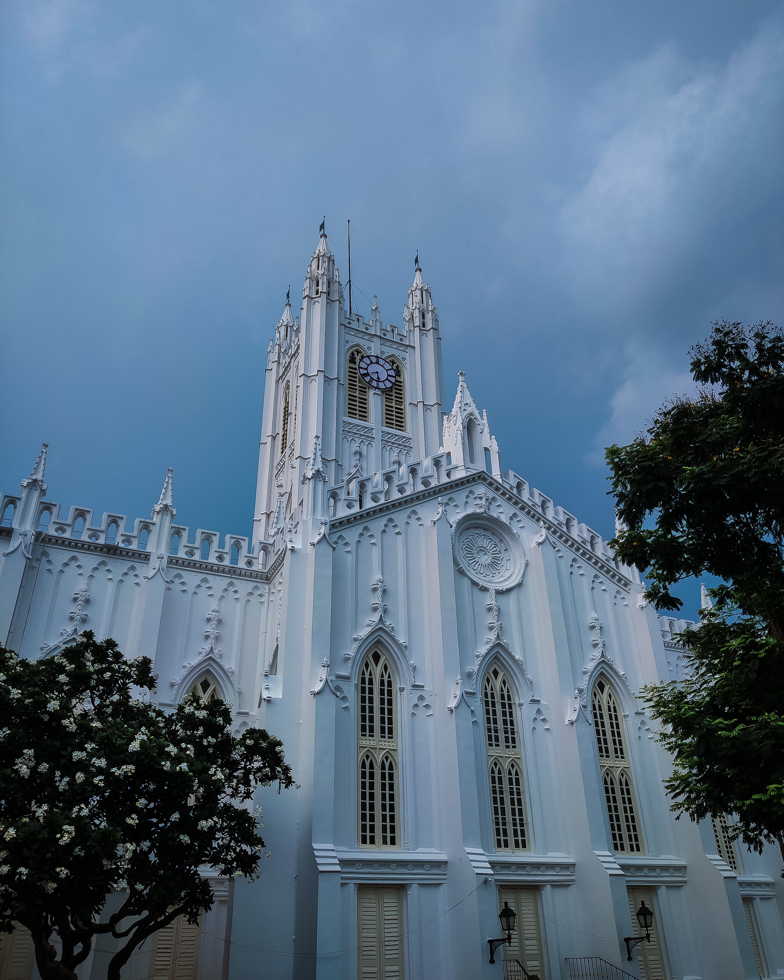 Low-angle view of St. Paul's Cathedral in Kolkata with gothic architecture and dramatic sky.