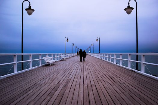 Couple walks on pier