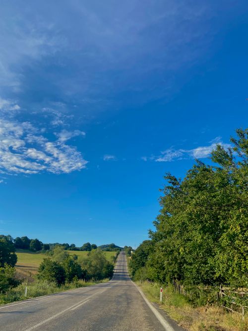 Free Long countryside road in Balıkesir, Türkiye, under a vibrant blue sky with lush greenery. Stock Photo