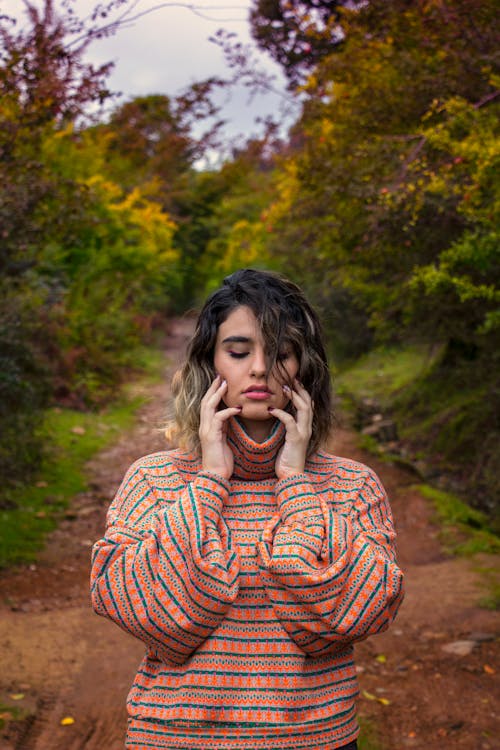 Woman in Striped Turtle Neck Long Sleeves Holding Her Face 