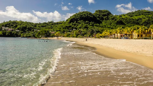 Photo of Beach Near Green Mountain Under Cloudy Sky