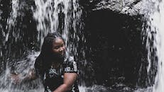 一位圣文森特女子在瀑布前欣赏自然美景的肖像