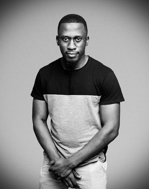 Black and White Photo of Man in Crew Neck Shirt Wearing Eyeglasses 