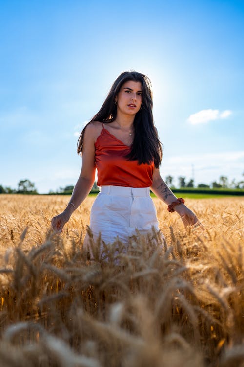 Model in a Red Satin Spaghetti Strap Blouse and White Shorts in a Wheat Field