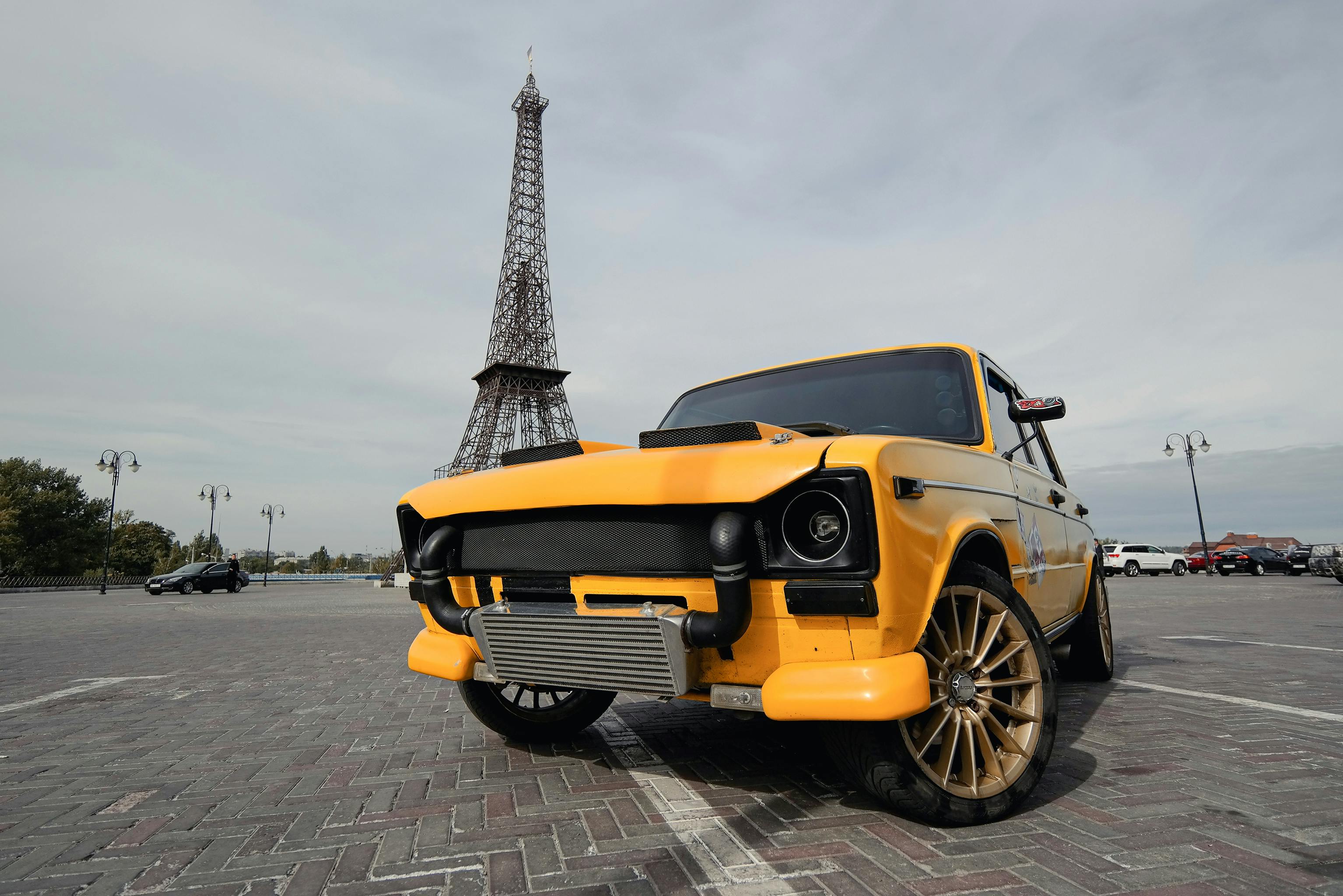 a yellow car near eiffel tower