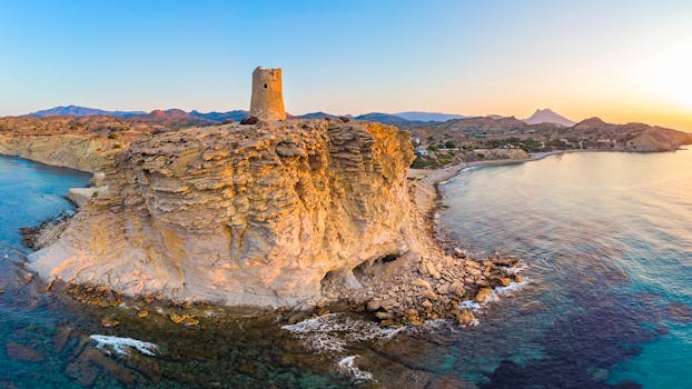 沿海悬崖的壮丽景色和历史悠久的塔楼，在日出时展现了自然美景