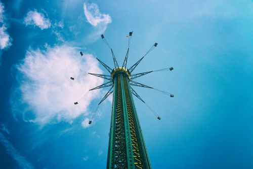 Free Low angle view of a thrilling swing ride against a vibrant blue sky in Vienna, Austria. Stock Photo