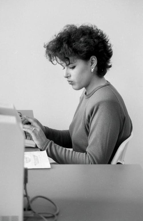 Black and White Photo of a Woman at a Computer