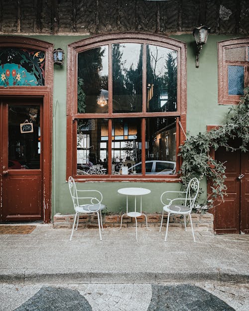 Table and Chairs Outside an Establishment Near Green Plants