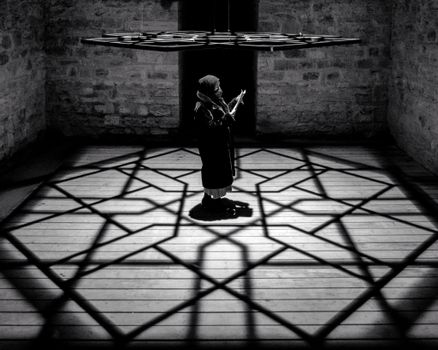 Person Standing Under a Hanging Metal Ornament