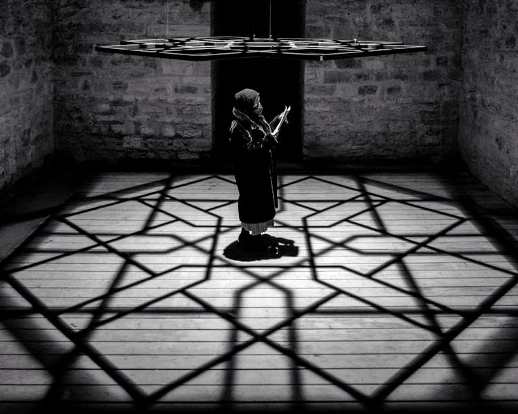 Person Standing Under A Hanging Metal Ornament