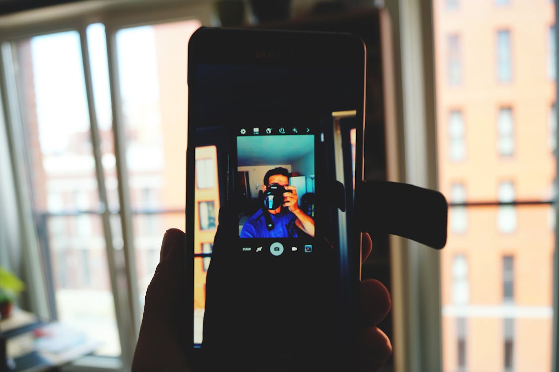 бесплатная человек, держащий черный смартфон Android Стоковое фото