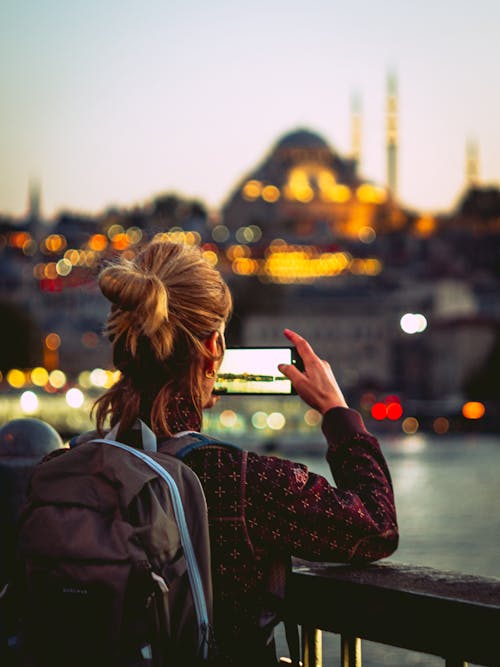 Woman Wearing Backpack Taking Picture of the View 