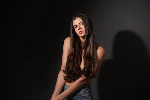 Topless Woman With Long Hair in Black Background 