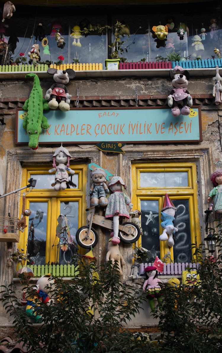 Rug Dolls Hanging On Windows Of A House