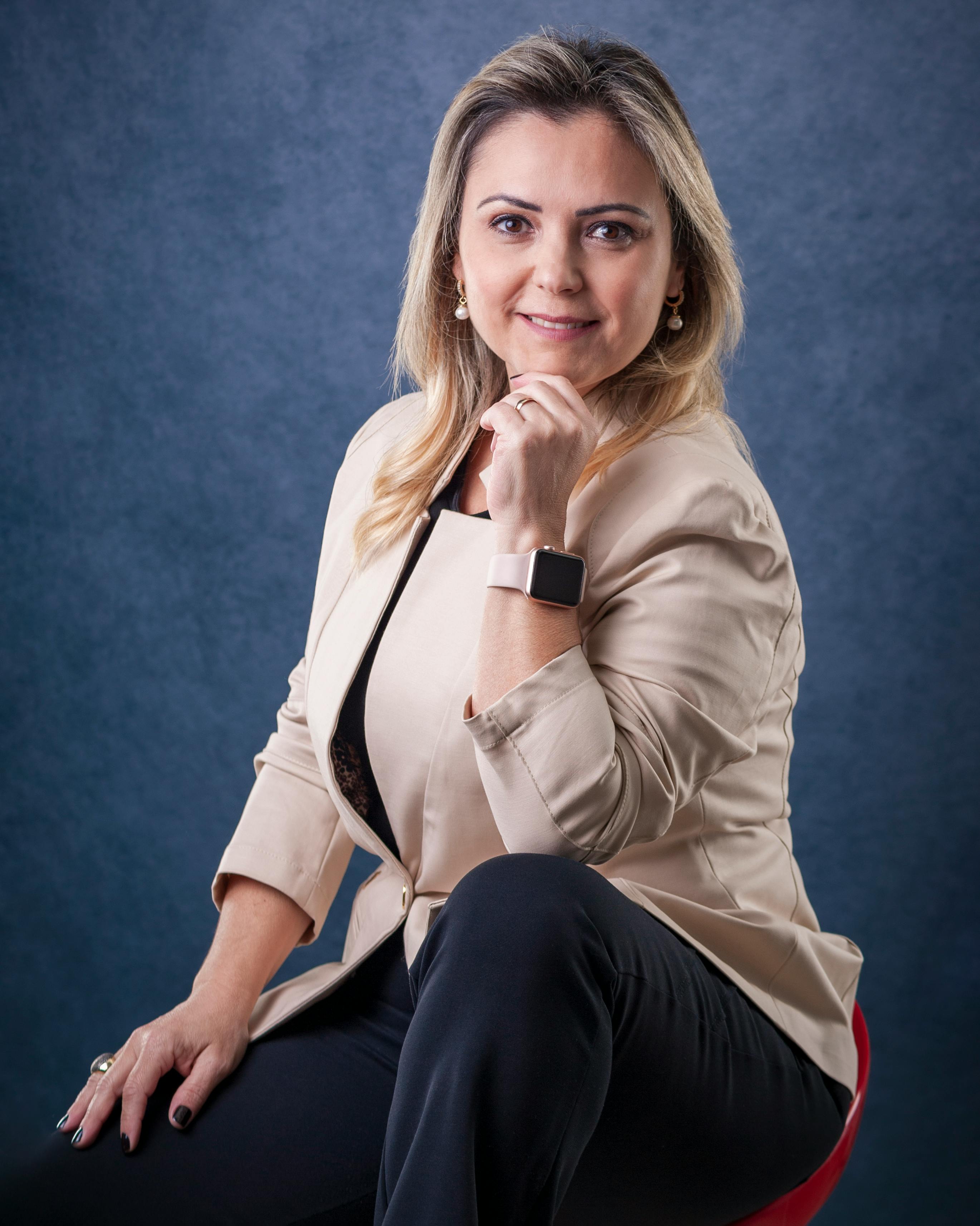Elegant woman in beige blazer posing confidently in studio portrait