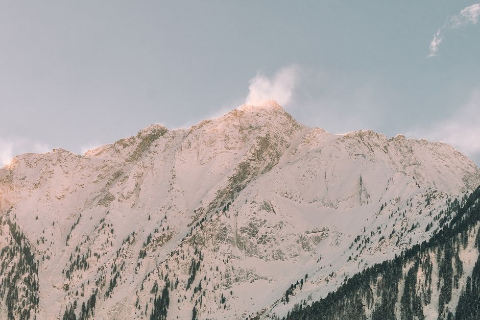 Beautiful snow-covered mountain peaks under a clear sky, captured at sunset with a scenic landscape view.