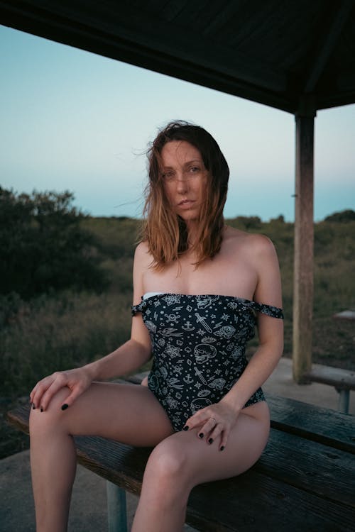 Woman inn Black Bikini Sitting on Wooden Bench 