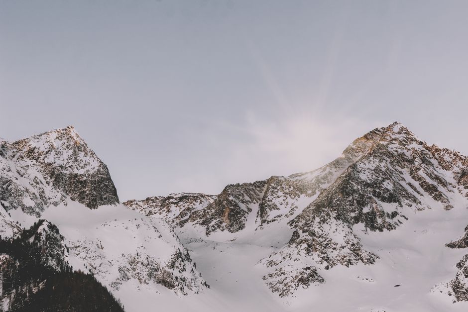 Spectacular view of serene snow-capped mountain peaks bathed in soft sunrise light.
