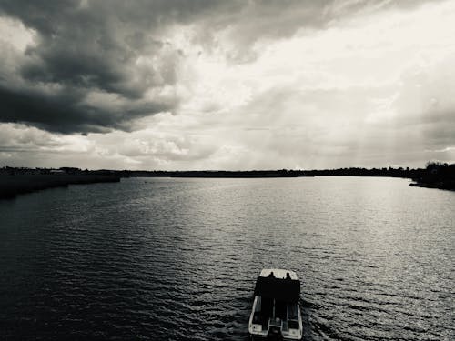 Grayscale Photo of Boat on Lake