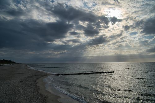 Free A scenic view of the ocean at Wustrow Beach, Germany with dramatic clouds and sunlight. Stock Photo