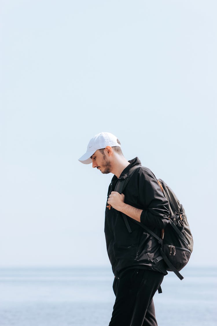 Man In Black Jacket And Pants Wearing Backpack And Cap 