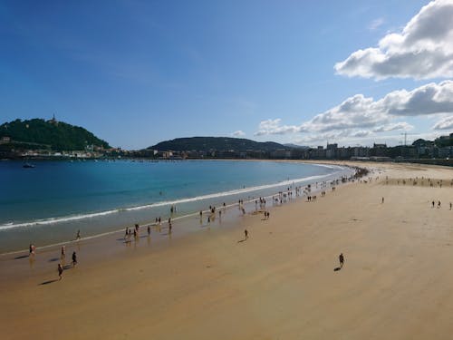 People on Beach Under White Clouds and Blue Sky 