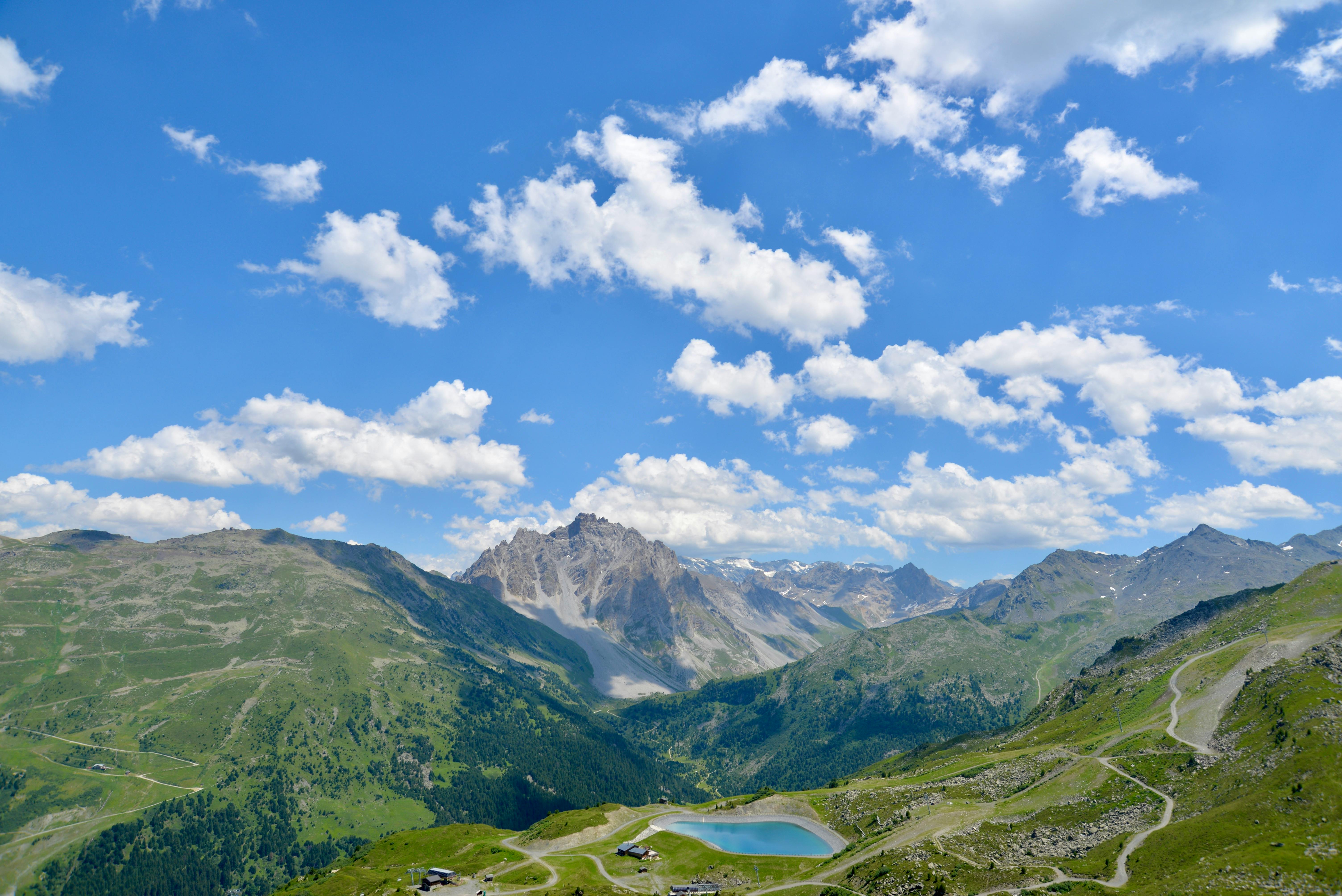 Scenic aerial view of the Bavarian Alps in summer with clear blue skies and lush greenery.